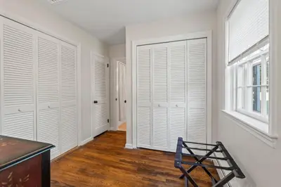 a room with white closet doors and a chair at New Pristine Suburban Escape in Newtown Square