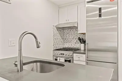 a kitchen with a sink and a stainless steel refrigerator at Washington Square West in Philadelphia