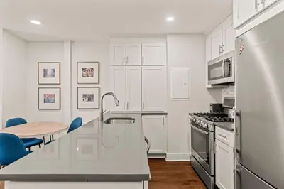 a kitchen with white cabinets and a table and a refrigerator at Washington Square West in Philadelphia
