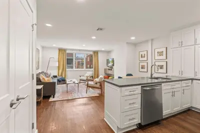 a kitchen with white cabinets and a living room at Washington Square West in Philadelphia