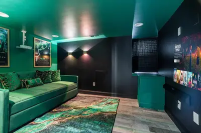 a living room with a green couch and a rug at Chic Urban Oasis Movie Theatre in Philadelphia