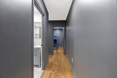 a hallway with grey walls and wooden floors at Chic Urban Oasis Movie Theatre in Philadelphia
