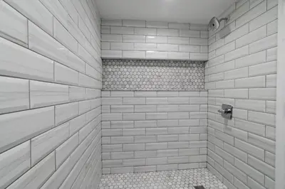a bathroom with a shower with white tiles at Chic Urban Oasis Movie Theatre in Philadelphia
