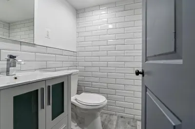 a white bathroom with a toilet and a sink at Chic Urban Oasis Movie Theatre in Philadelphia