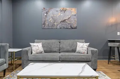 a living room with a couch and a painting on the wall at Chic Urban Oasis Movie Theatre in Philadelphia