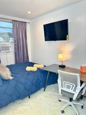 a bedroom with a bed and a desk and a tv at BP STAYS - Hotel-Style, No Host, Professionally Managed ID260 in Jersey City