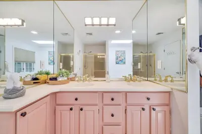 a pink bathroom with two sinks and a large mirror at Heated Private Pool Hot Tub Game Room Sauna in Stroudsburg