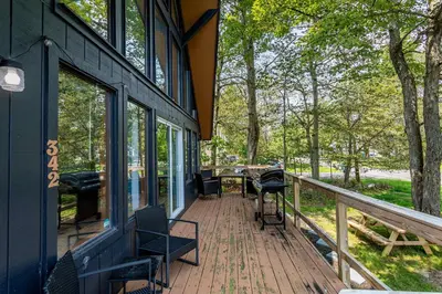 a porch of a house with a table and chairs at Blue Diamond Hot Tub Fire Pit 3 BDR in Tobyhanna