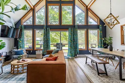 a living room with large windows and a couch at Blue Diamond Hot Tub Fire Pit 3 BDR in Tobyhanna