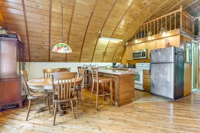 a kitchen with a table and a stainless steel refrigerator at Hike and Fish Delaware River Cabin with Views in East Branch