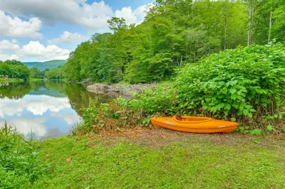 an orange kayak sitting on the shore of a lake at Hike and Fish Delaware River Cabin with Views in East Branch