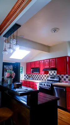 a kitchen with red cabinets and a black counter top at Morristown Charm in Morristown