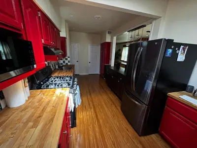 a kitchen with red cabinets and a black refrigerator at Morristown Charm in Morristown