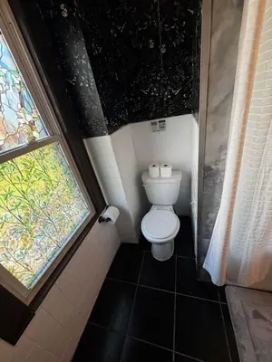 a bathroom with a toilet and a window at Morristown Charm in Morristown