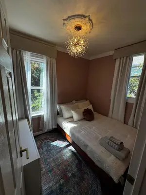 a bedroom with a bed with a chandelier and two windows at Morristown Charm in Morristown