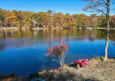 a person bending over in front of a lake at Lakefront Kayaks, HotTub FirePit Sauna Pool in East Stroudsburg