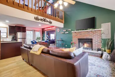 a living room with a couch and a fireplace at Hot tub - Game Loft & Arcade - 2 King Beds - Pet Friendly in Tobyhanna