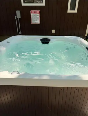 a jacuzzi tub filled with blue water at Hot tub - Game Loft & Arcade - 2 King Beds - Pet Friendly in Tobyhanna
