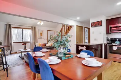 a kitchen and dining room with a wooden table and blue chairs at Hot tub - Game Loft & Arcade - 2 King Beds - Pet Friendly in Tobyhanna