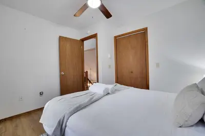 a bedroom with a white bed with a ceiling fan at Hot tub - Game Loft & Arcade - 2 King Beds - Pet Friendly in Tobyhanna
