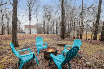 a group of four chairs around a fire pit at Hot tub - Game Loft & Arcade - 2 King Beds - Pet Friendly in Tobyhanna