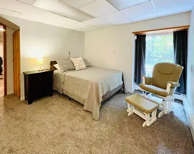 a bedroom with a bed and a chair at Hidden River Lodge at Hawk Mountain