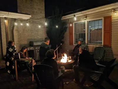 a group of people sitting around a fire at night at Hidden River Lodge at Hawk Mountain