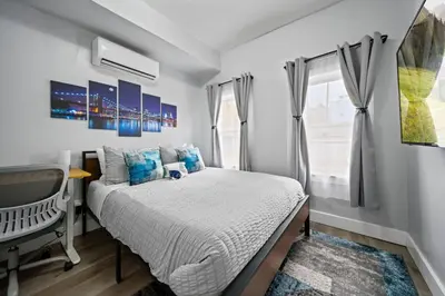 a bedroom with a bed and a desk and a television at Newly renovated luxury 3BR Condo! 30 mins to NYC in Jersey City
