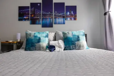 a bedroom with a bed with a city at night at Newly renovated luxury 3BR Condo! 30 mins to NYC in Jersey City