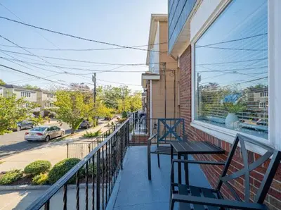 a balcony with two benches and a table on a building at Modern 3BR Near EWR, Parking, 25 Min NYC in Kearny