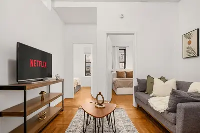 a living room with a couch and a tv at Chic East Village Retreat Comfort in Heart of NYC in New York