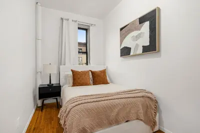 a bedroom with a bed and a picture on the wall at Chic East Village Retreat Comfort in Heart of NYC in New York
