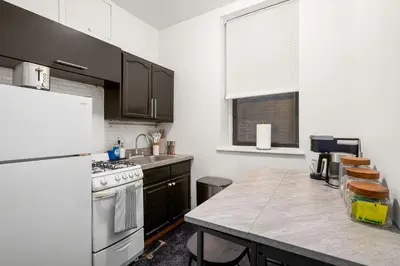 a kitchen with a white refrigerator and a counter top at Chic East Village Retreat Comfort in Heart of NYC in New York
