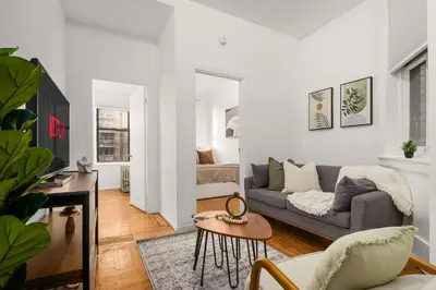 a living room with a couch and a table at Chic East Village Retreat Comfort in Heart of NYC in New York