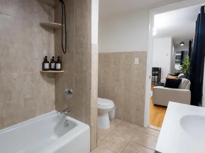 a bathroom with a bath tub and a toilet at Elegant NYC View Stay Park Free 6 beds Sleep 8 in Kearny