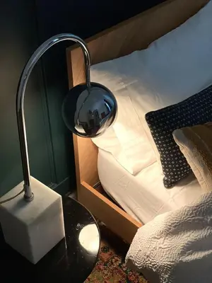 a lamp on a table next to a bed at Garden Oasis 3BR 23min NYC PATH in Harrison