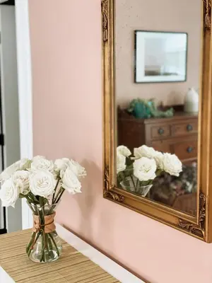 a vase of white flowers sitting on a table in front of a mirror at Garden Oasis 3BR 23min NYC PATH in Harrison