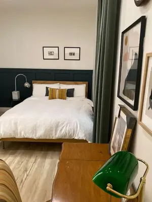 a bedroom with a bed and a green chair at Garden Oasis 3BR 23min NYC PATH in Harrison
