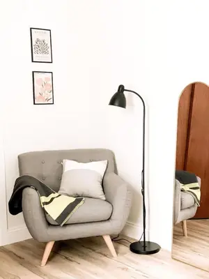 a living room with a gray couch and a floor lamp at Garden Oasis 3BR 23min NYC PATH in Harrison