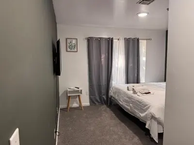 a bedroom with a bed and a window with curtains at Large 2Kings 2 bedroom 2 bath by EWR NYC Downtown Newark in Newark