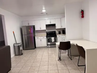 a kitchen with white cabinets and stainless steel appliances at Large 2Kings 2 bedroom 2 bath by EWR NYC Downtown Newark in Newark