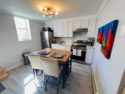 a kitchen with a wooden table and a refrigerator at Renovated private urban flat - 20 min to Manhattan NYC in Jersey City