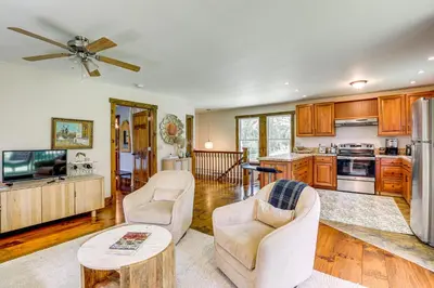 a living room with two chairs and a kitchen at Walk to River Couples Retreat in Kintnersville! in Kintnersville