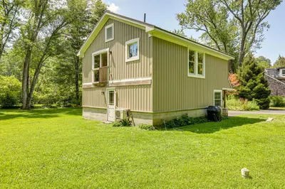 a green house in a yard with a grass field at Walk to River Couples Retreat in Kintnersville! in Kintnersville