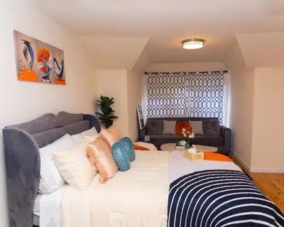 a bedroom with a large bed and a couch at Luxury Vibes ,Cozy Location in East Orange