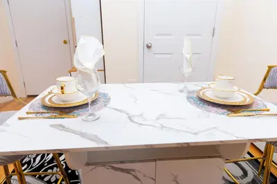 a white marble table with two cups and plates on it at Luxury Vibes ,Cozy Location in East Orange