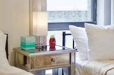 a table with a lamp on it next to a bed at Stay In Times Square! 2-Bedroom Apartments in New York