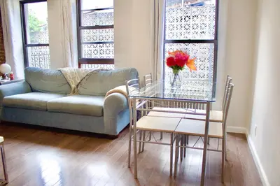 a living room with a glass table and a couch at Stay In Times Square! 2-Bedroom Apartments in New York
