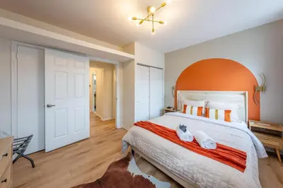a bedroom with a large bed with an orange headboard at Stylish 2 BD Apt-18 mins from NYC-Steps away Bus stop, Restaurants, Groceries in Jersey City