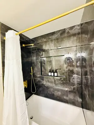 a bathroom with a tub and a shower curtain at Stylish 2 BD Apt-18 mins from NYC-Steps away Bus stop, Restaurants, Groceries in Jersey City